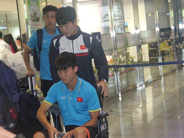 Duy Mạnh phải ngồi xe lăn sau chấn thương ở trận gặp Indonesia, được đồng đội Xuân Trường trợ giúp