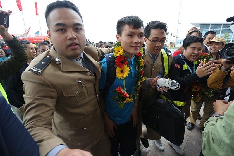 Quang Hải trong vòng vây của người hâm mộ sau khi đặt chân xuống sân bay Nội Bài trưa 28/1. 
