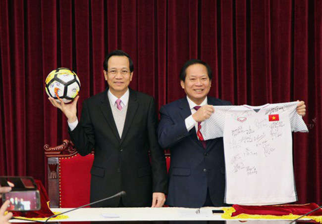 Bộ trưởng Bộ TT-TT Trương Minh Tuấn (phải) và Bộ trưởng LĐ-TB-XH Đào Ngọc Dung cùng áo đấu và quả bóng đá tuyển U23 Việt Nam tặng Thủ tướng
