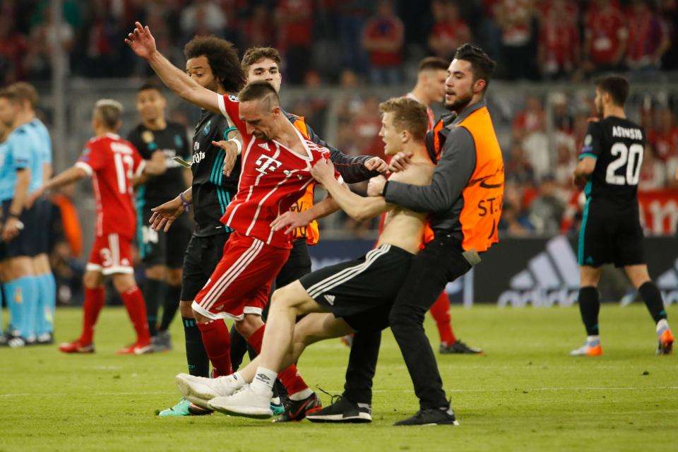 Một CĐV quá khích chạy lại gần túm áo Ribery bất chấp sự can ngăn của nhân viên bảo vệ sân