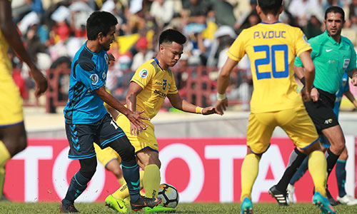 Ba điểm giành được từ Tampines Rovers giúp SLNA (áo vàng) rộng cửa vào vòng sau. 
