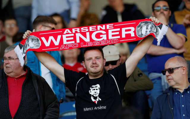 Một cổ động viên mặc áo có hình Wenger và mang cả một chiếc khăn lưu niệm có tên của chiến lược gia người Pháp