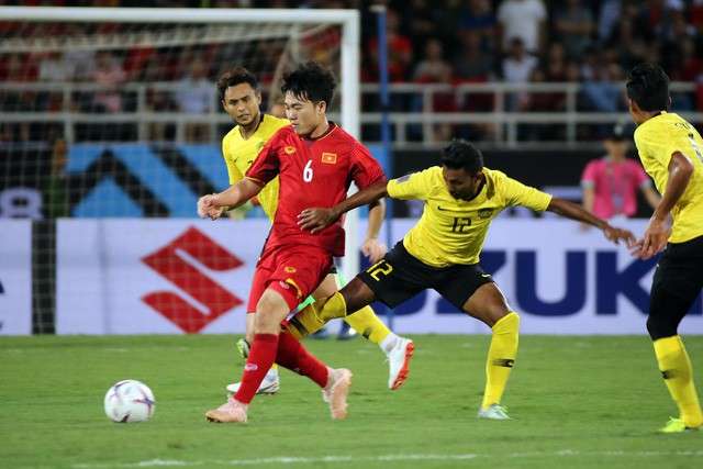 Đội tuyển Việt Nam (áo đỏ) thể hiện lối chơi trên chân trước Malaysia